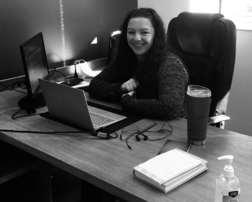 Stacy Orchard at desk in Newark office B&W